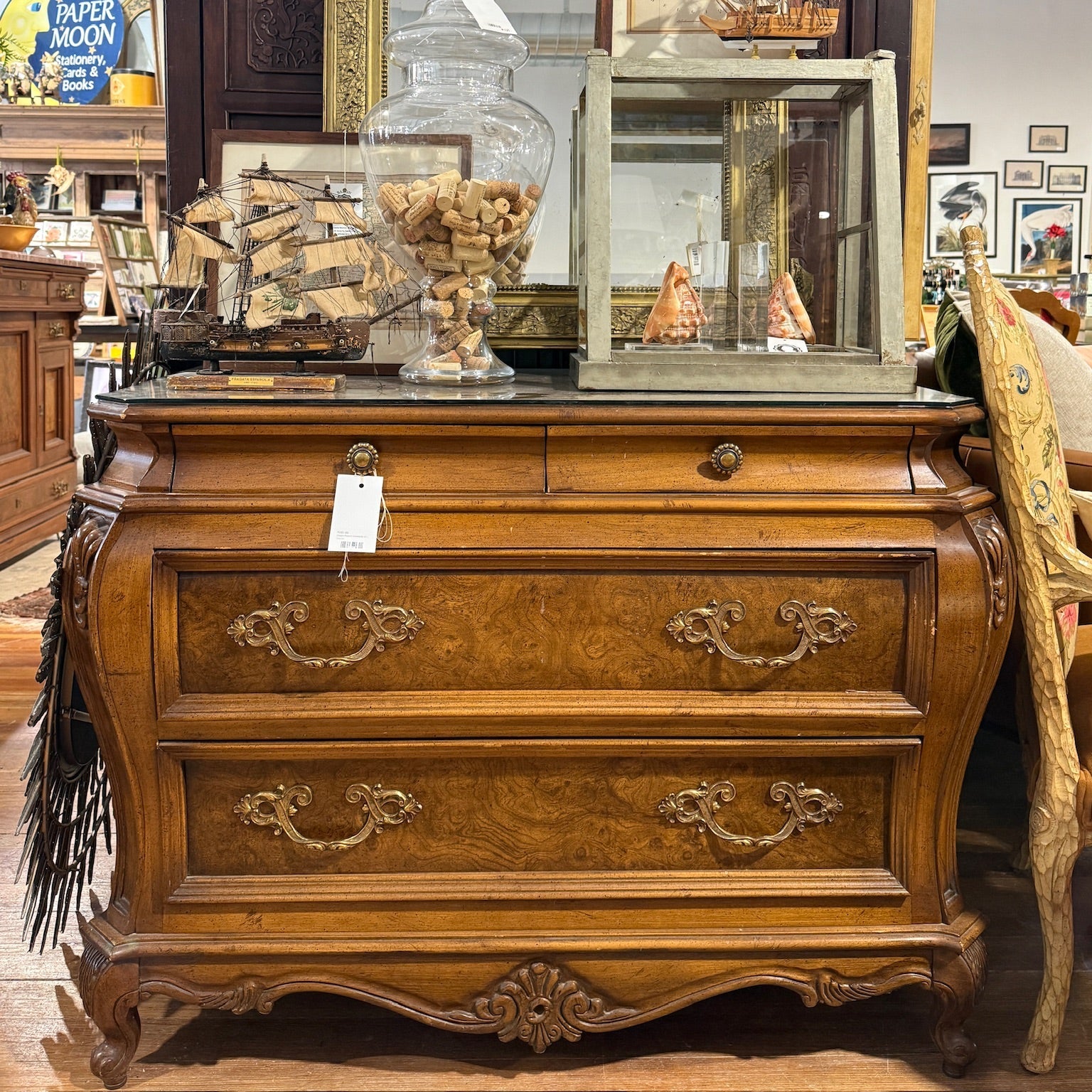 Wooden dresser with decorative items including a mirror and glass display cases.